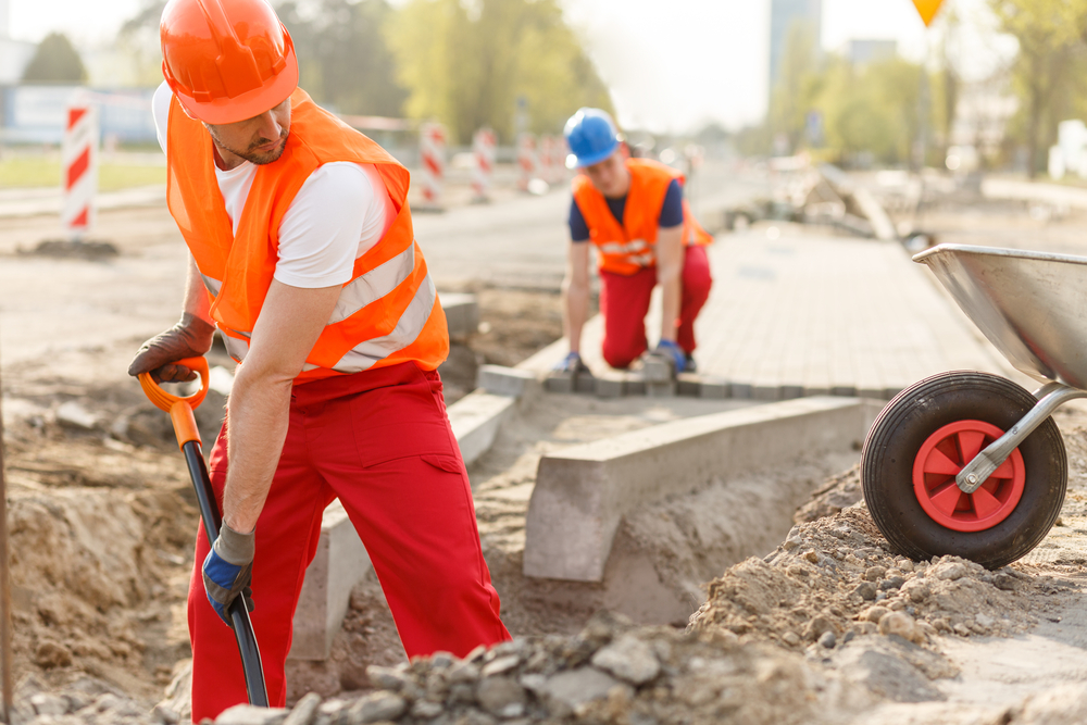 Two,Hard,Working,Builders,In,Uniforms,Putting,Pavement