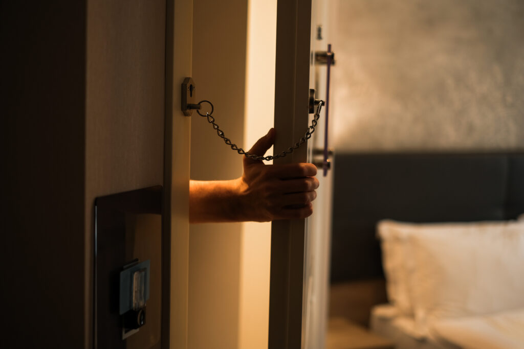 a burglar tries to enter a door locked with a chain lock